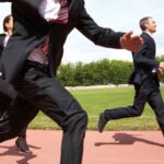 sales reps in suit run on a school running track